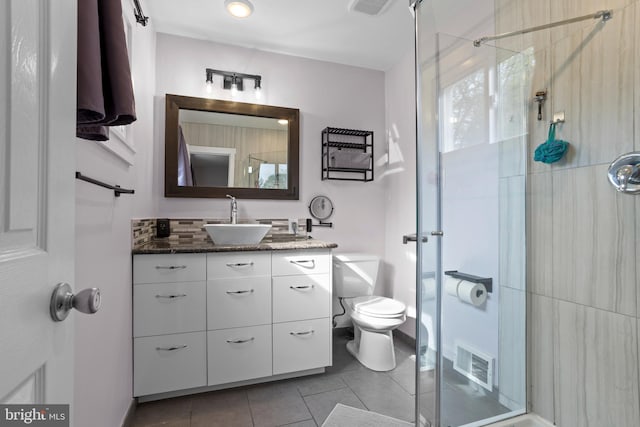 bathroom with tile patterned flooring, visible vents, toilet, vanity, and walk in shower
