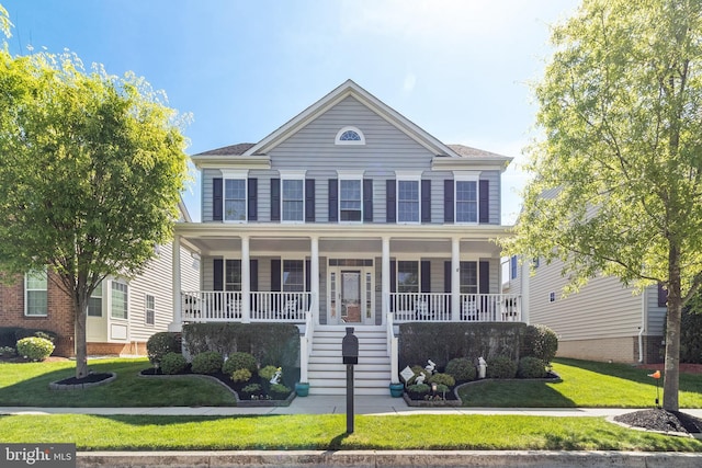 colonial home with a porch, stairway, and a front yard
