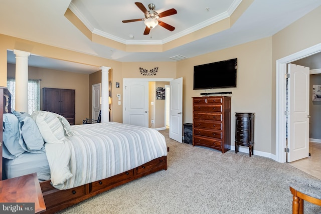 bedroom with a raised ceiling, carpet flooring, ornamental molding, and decorative columns