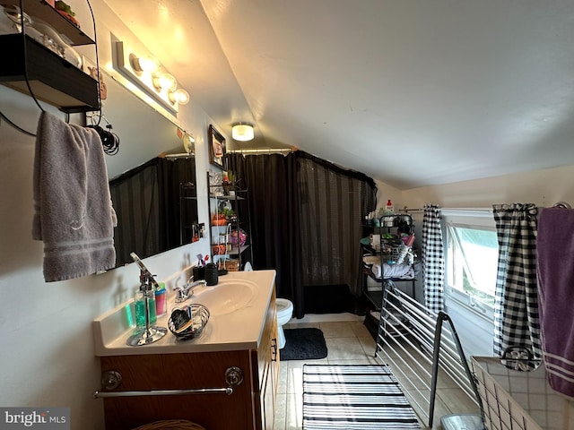 bathroom with toilet, tile patterned flooring, vanity, and vaulted ceiling