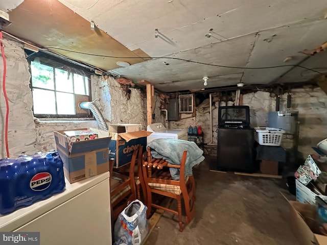 below grade area featuring gas water heater, washer and clothes dryer, and electric panel
