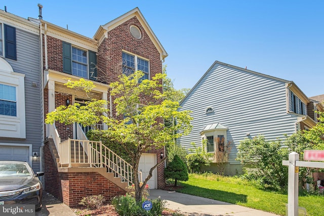 view of front facade with an attached garage, concrete driveway, and brick siding