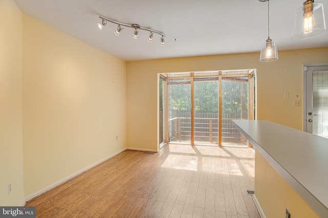 interior space with baseboards and light wood-style flooring