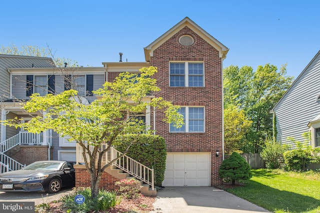 townhome / multi-family property with a front yard, stairway, brick siding, concrete driveway, and an attached garage