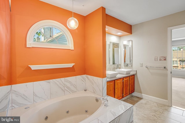 full bath with baseboards, a tub with jets, and vanity