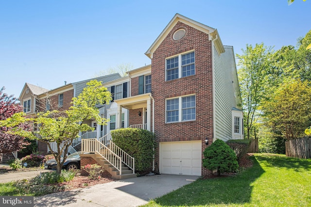 view of property featuring brick siding, a front lawn, an attached garage, and driveway