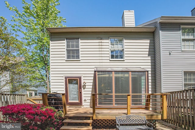 rear view of house with a chimney and a deck