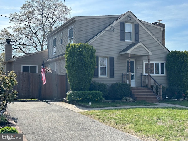 view of front of house with a front yard and fence