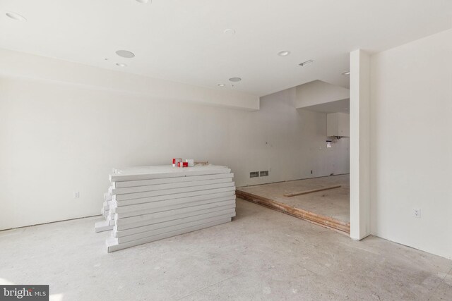 empty room with concrete floors and visible vents
