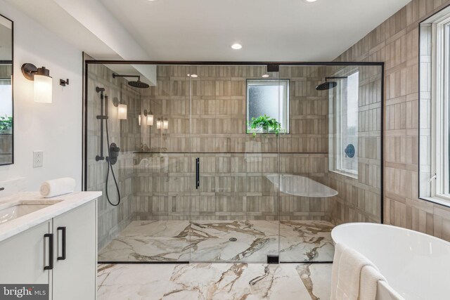 bathroom with vanity, marble finish floor, a shower stall, and a soaking tub