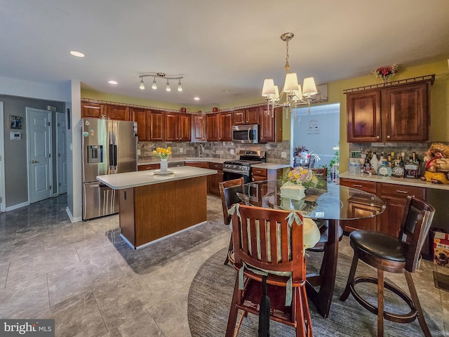 17616 Chisholm Ln, Dumfries, VA 22026 - kitchen featuring stainless steel appliances, light countertops, tasteful backsplash, a chandelier, and a center island