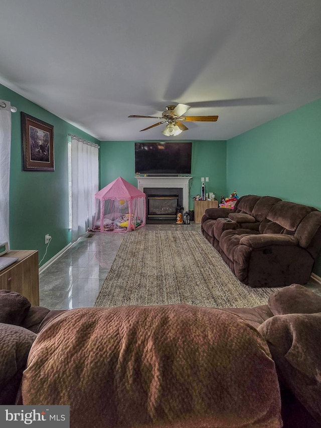 17616 Chisholm Ln, Dumfries, VA 22026 - living area with ceiling fan, a glass covered fireplace, and baseboards