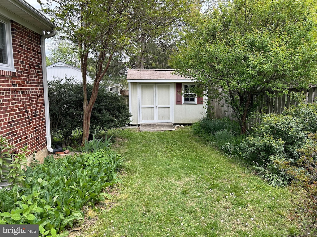 view of grassy yard featuring a storage unit and an outdoor structure