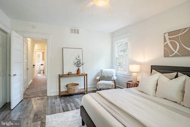 bedroom with baseboards, ceiling fan, visible vents, and wood finished floors