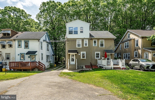 view of front of home with a front yard and a wooden deck