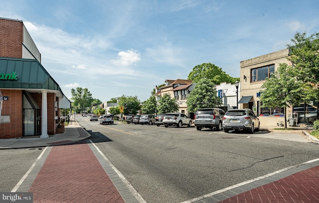 view of street featuring street lights, a residential view, curbs, and sidewalks
