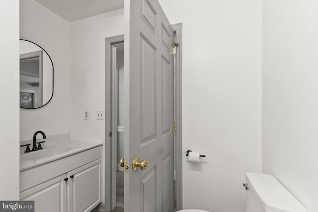 half bathroom with vanity and toilet