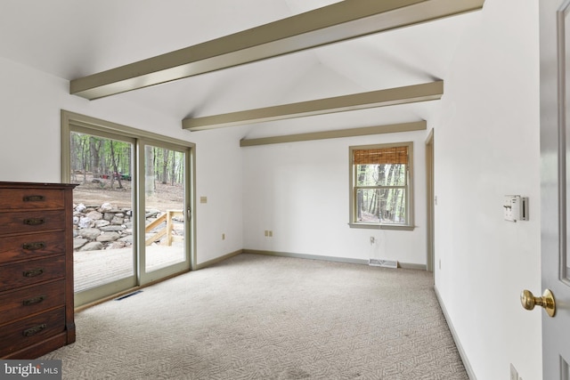 unfurnished room featuring visible vents, lofted ceiling with beams, plenty of natural light, and carpet