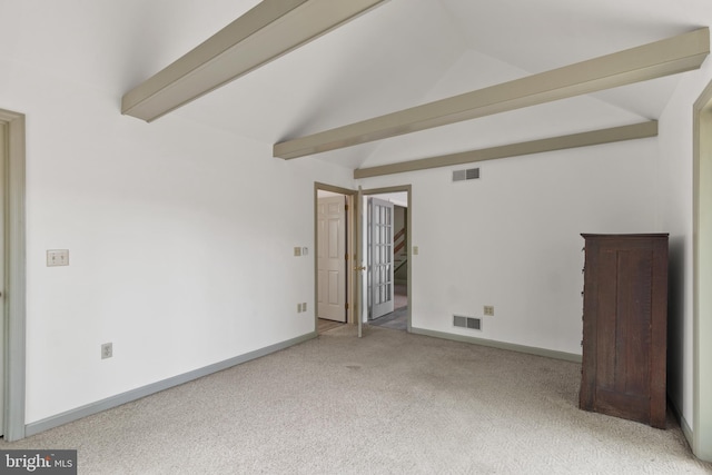 carpeted empty room featuring visible vents, lofted ceiling with beams, and baseboards