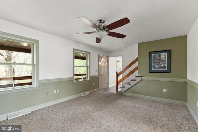 empty room with a healthy amount of sunlight, stairway, carpet, and visible vents