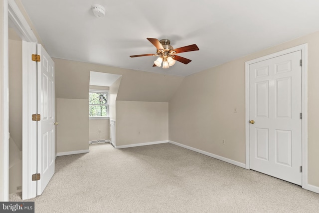 additional living space with baseboards, a ceiling fan, lofted ceiling, and light colored carpet