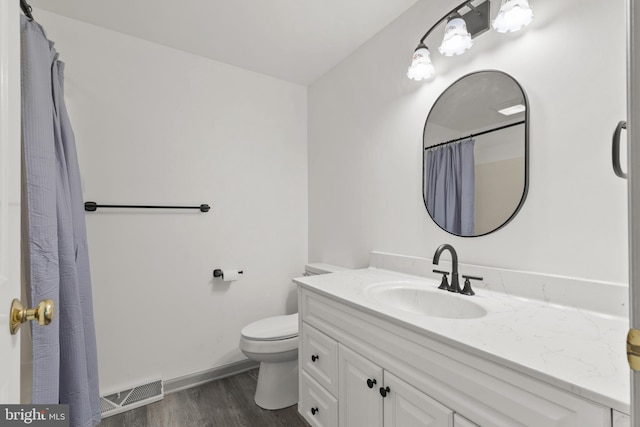 full bath with vanity, toilet, baseboards, wood finished floors, and visible vents