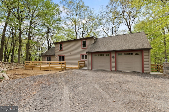 view of front of house featuring a garage, roof with shingles, and a deck