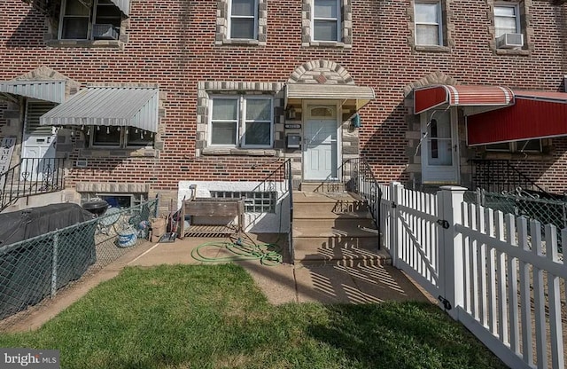 back of house featuring brick siding, fence, and cooling unit
