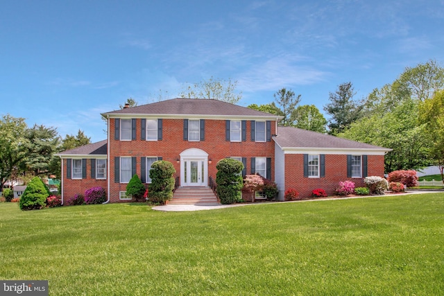 colonial-style house with a front lawn and brick siding