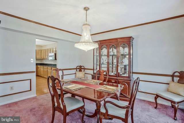 dining area featuring crown molding, light carpet, baseboards, and a notable chandelier