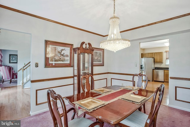 dining space with light colored carpet, an inviting chandelier, and crown molding