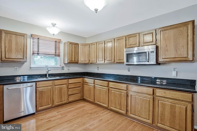 kitchen featuring a sink, stainless steel appliances, and light wood-style floors