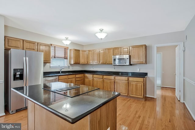 kitchen with dark countertops, appliances with stainless steel finishes, and a sink