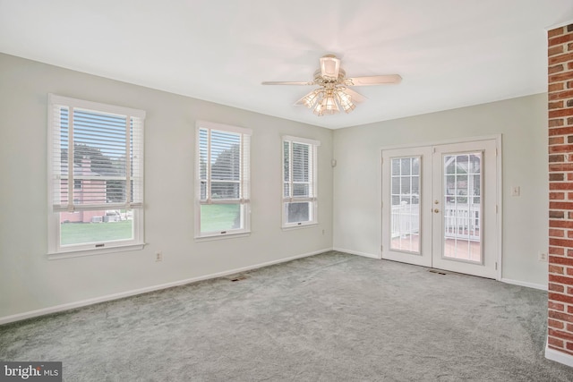 carpeted empty room with french doors, baseboards, and ceiling fan