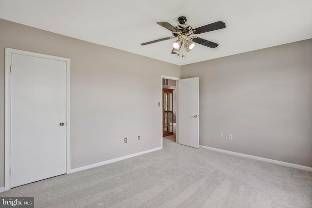 unfurnished bedroom with carpet flooring, baseboards, and a ceiling fan