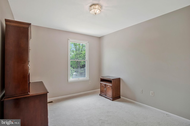 empty room with light carpet and baseboards