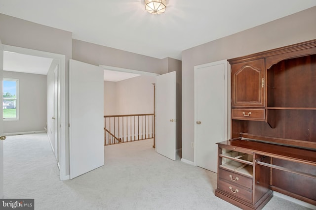 unfurnished office with baseboards and light carpet