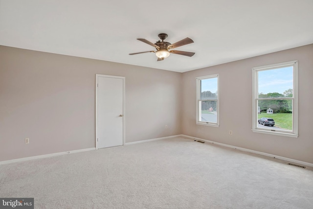 unfurnished room with light carpet, baseboards, and ceiling fan