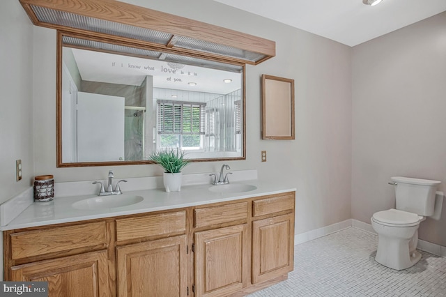 bathroom featuring double vanity, toilet, a stall shower, and a sink