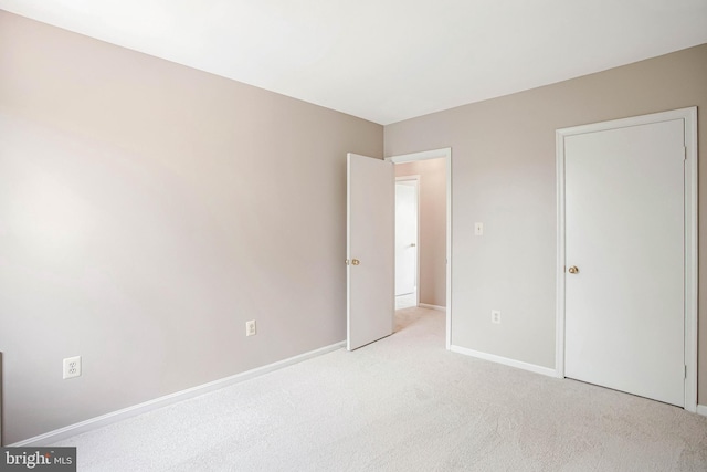 unfurnished bedroom with carpet flooring and baseboards