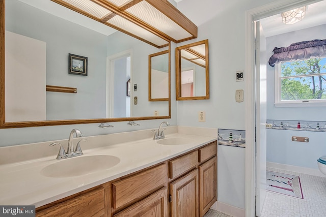 bathroom featuring a sink, double vanity, toilet, and tile patterned flooring