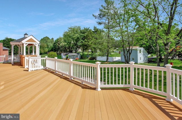 wooden terrace with a gazebo and an outbuilding