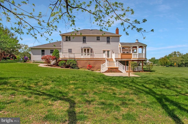 rear view of property with a lawn, stairway, a chimney, and a wooden deck
