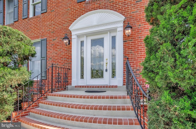 view of exterior entry featuring brick siding
