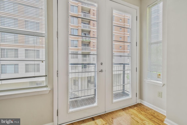 doorway to outside featuring baseboards and wood finished floors