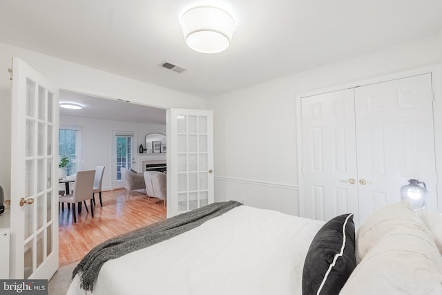 1541 Church Hill Pl Unit 1541, Reston, VA 20194 - bedroom with a closet, french doors, visible vents, light wood-style floors, and a fireplace
