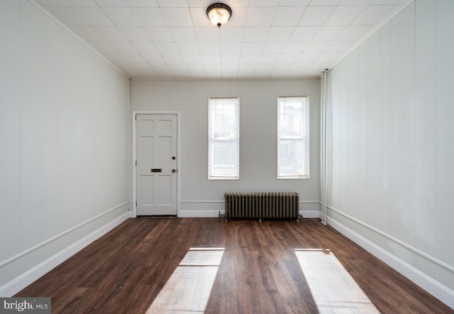 interior space with radiator heating unit, baseboards, and dark wood-style flooring