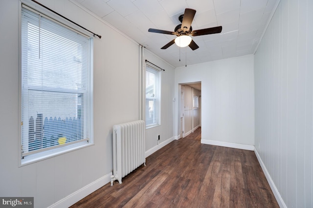 unfurnished room featuring ceiling fan, radiator heating unit, crown molding, and dark wood-style floors