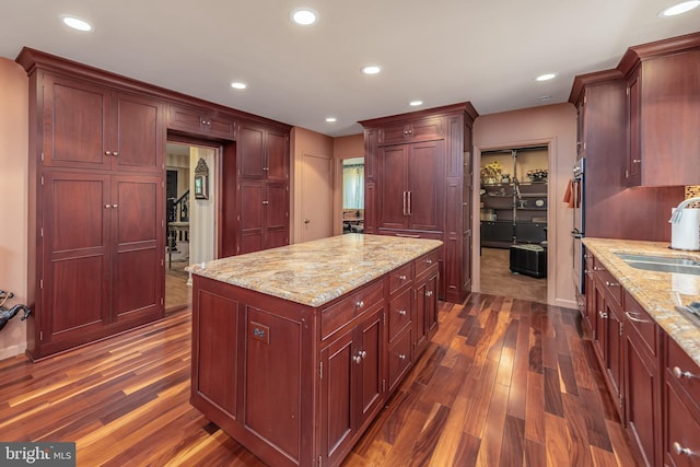 kitchen with dark wood finished floors, recessed lighting, dark brown cabinets, and a sink