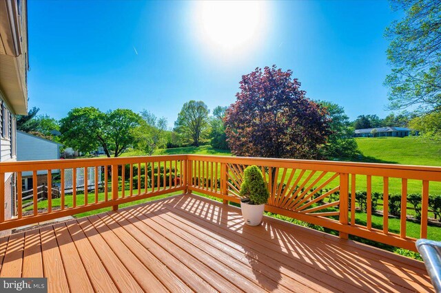 wooden deck featuring a lawn